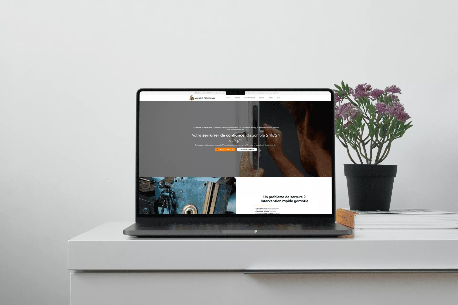 Mockup du site web fictif Aux Bons Trousseaux affiché sur un ordinateur portable, posé sur un bureau blanc avec une plante et des livres en arrière-plan.